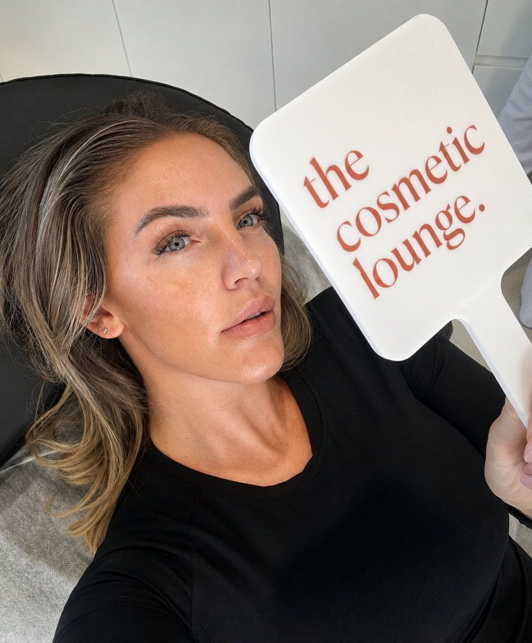 Client holding The Cosmetic Lounge mirror following a personalised cosmetic consultation